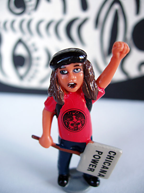 A figurine of a Chicana with fist raised