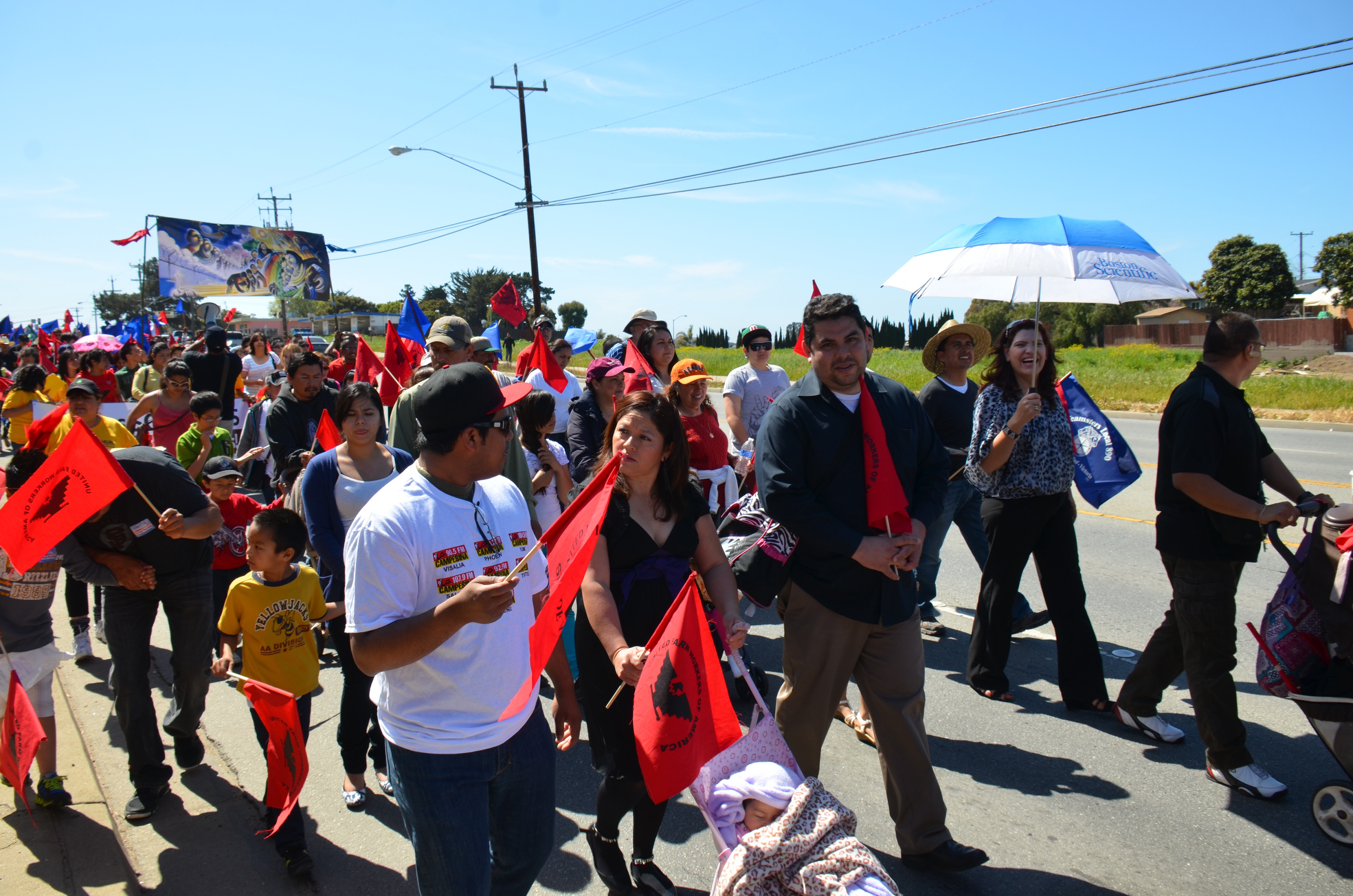 A group of people marching and holding red UFW flags