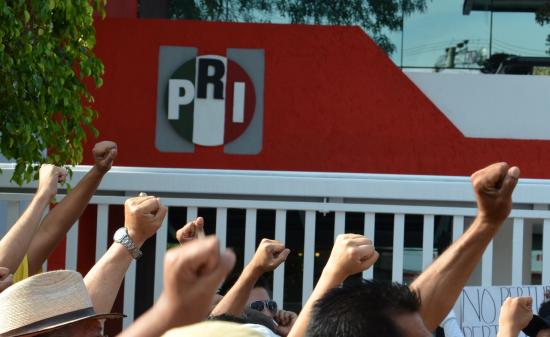 Protestors raise their fists against PRI