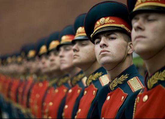Line of soldiers in red and black uniforms.