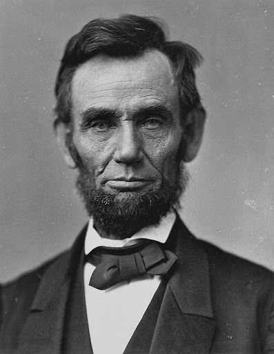 An iconic photograph of Abraham Lincoln dressed in a black suit and wearing a bow tie. 