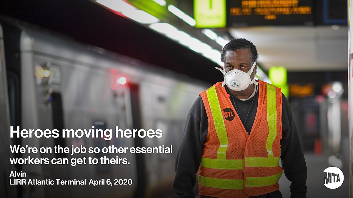 Poster photo for the Atlanta Terminal showing a subway car and a MTA subway worker in an orange and yellow vest wear and N95 mask. Reads "Heroes moving heroes. We're on the job so other essential workers can get to theirs".