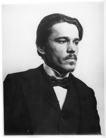 Historic photo of a middle-aged person in suit and bowtie.