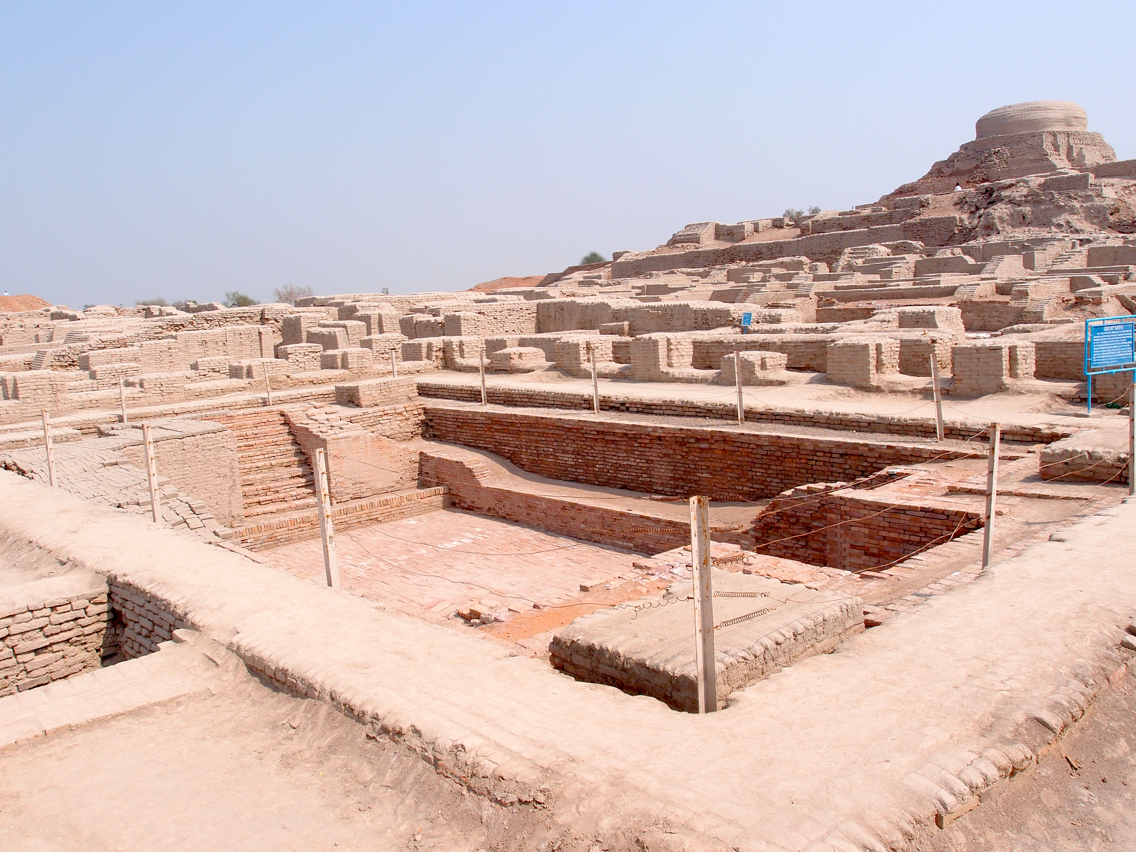 the Great Bath in the foreground of the remaining ancient ruins of Mohenjo Daro