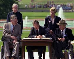 Picture of President Bush, three men and a woman outside signing legislation
