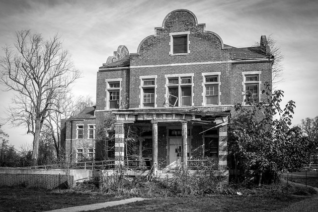 Black-and-white image of a crumbling building from Pennhurst State School and Hospital.