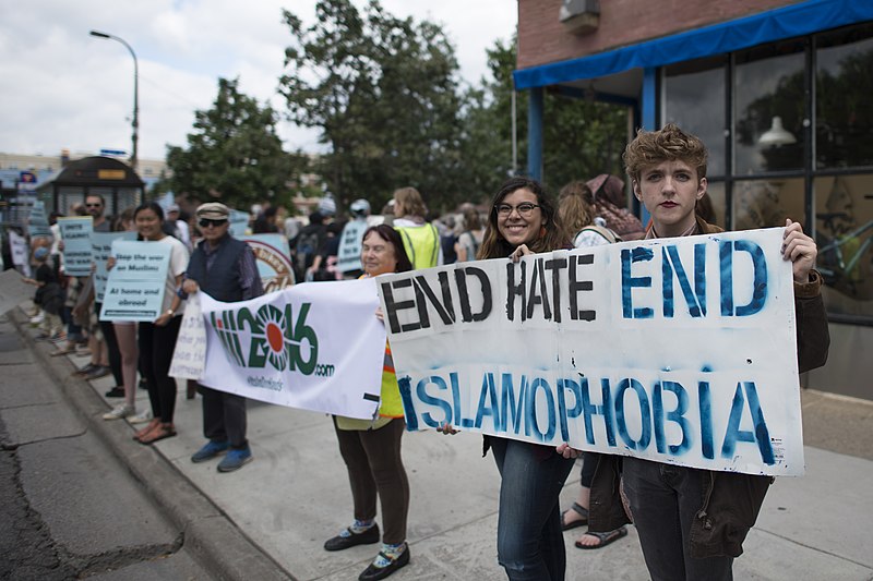 People demonstrating on the street, holding banners. One reads: end hate, end Islamophobia.