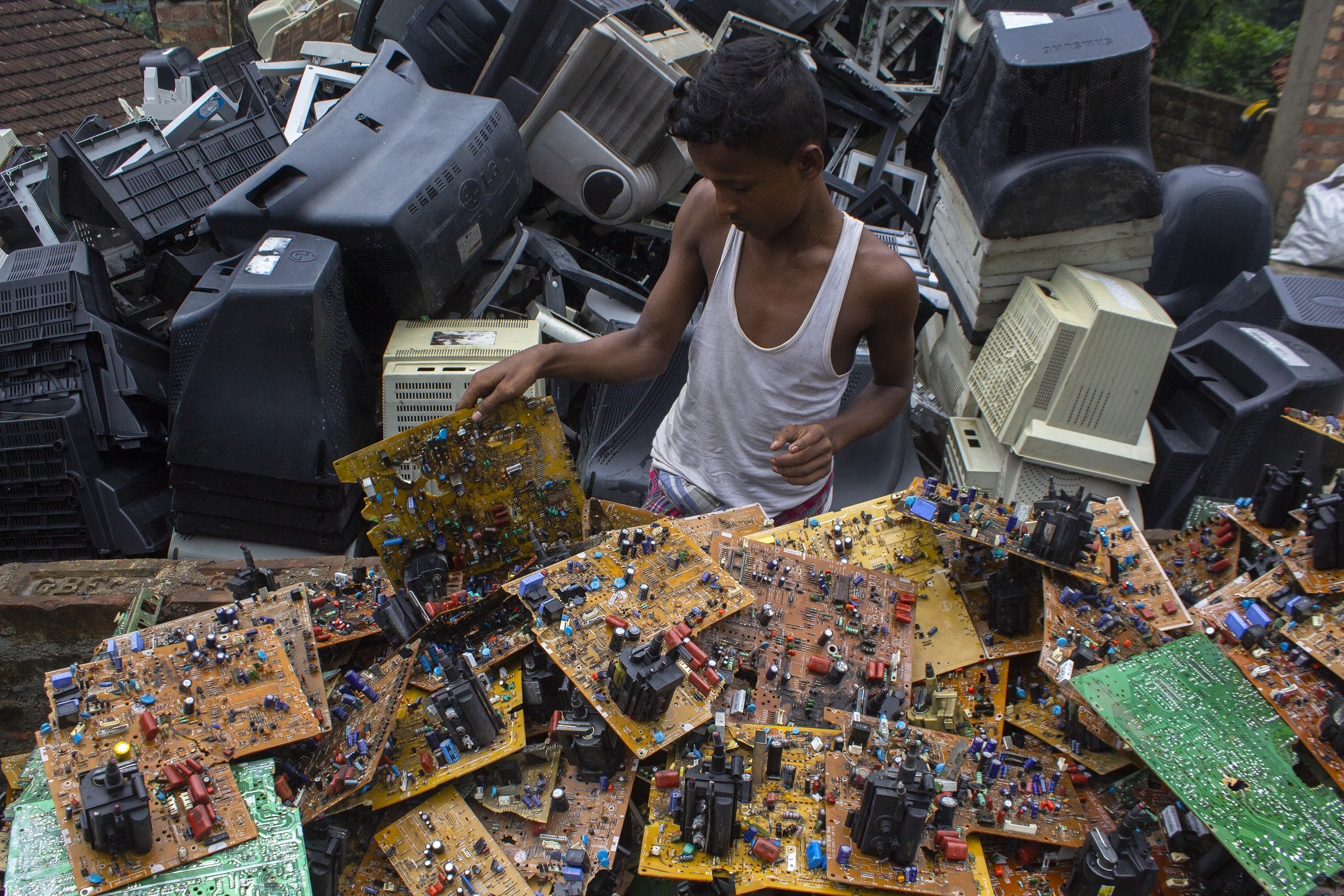 Young boy sorting through electronic waste