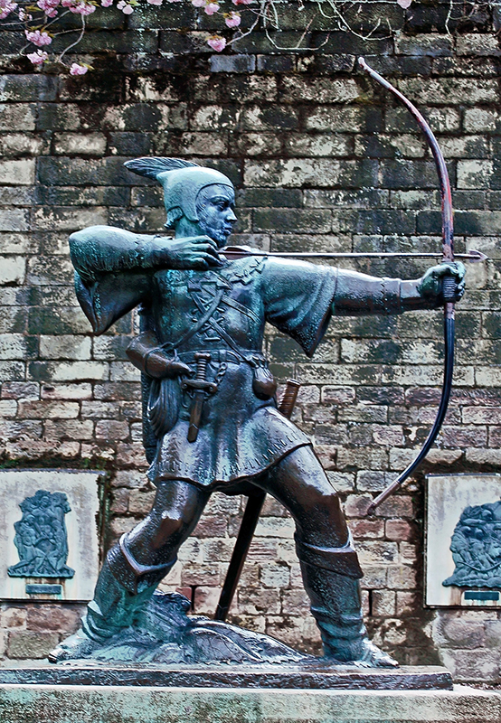 A modern statue shows Robin Hood placing an arrow in a bow to shoot.