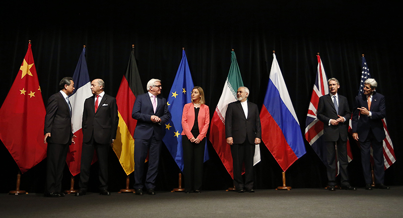 Representatives from China, France, Germany, the EU, Iran, the UK, and the US pose for a photo in front of their respective flags.