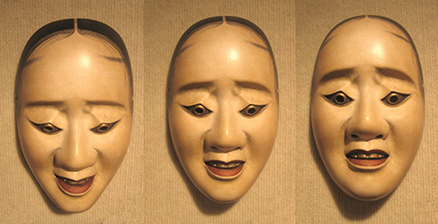 三个口罩并排排列。 口罩几乎相同，但由于口罩的角度不同，面部表情略有不同。 第一个面具向下倾斜，眼睛向下倾斜。 第二个面具直射显示，其视线略高于第一个面具。 第三个面具向上倾斜，因此其视线更向上。