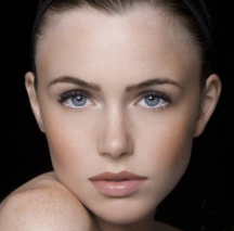Close-up portrait of a person against a dark background.