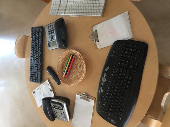 Phones, keyboards, and clipboards of paper with pencils