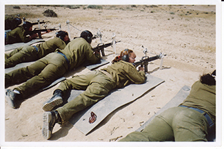 Una fotografía muestra a una mujer soldado armada entre un grupo de soldados.