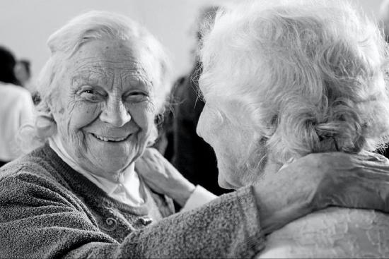 Two older women smiling and perhaps dancing