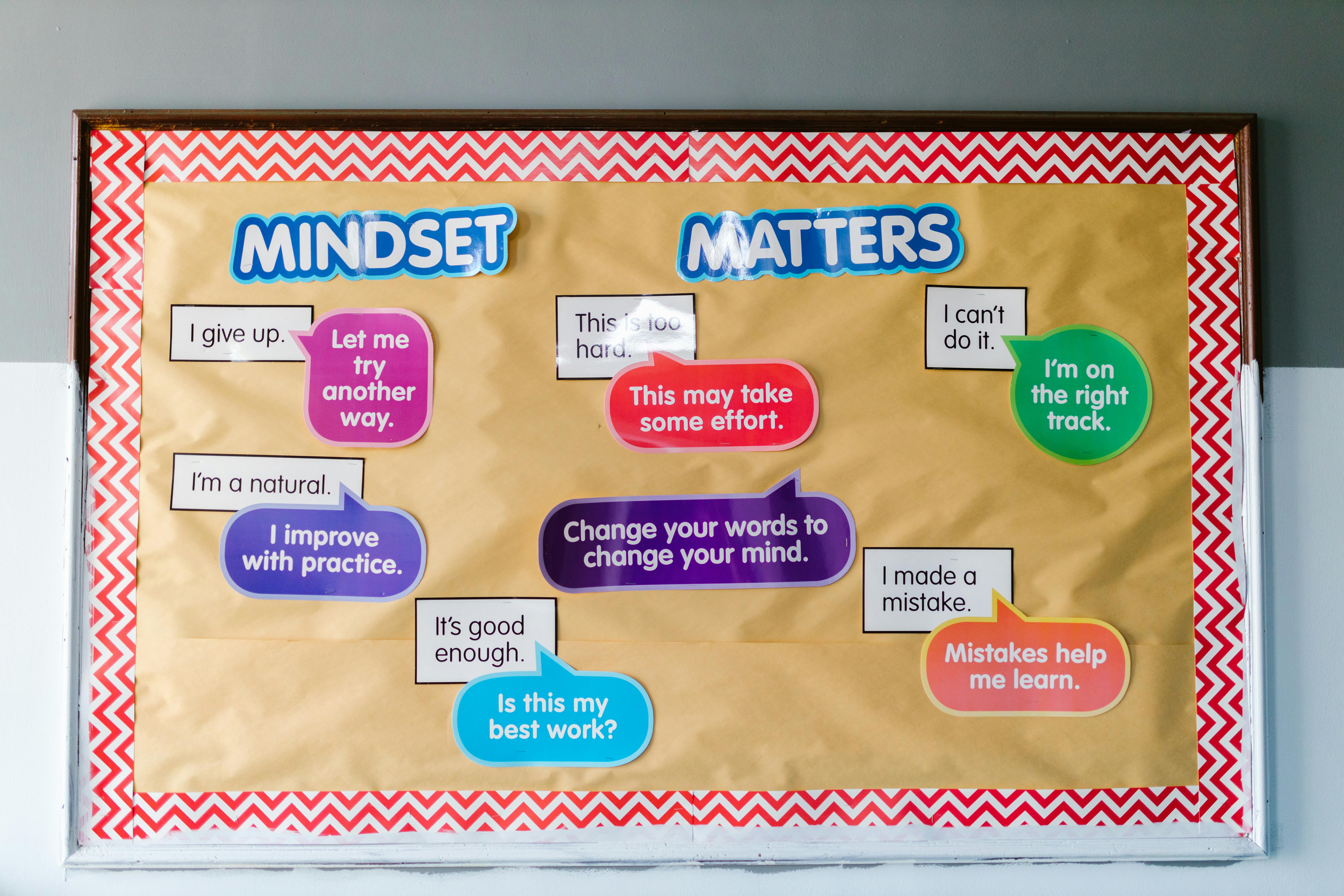 A bulletin board filled with inspirational messages showing the importance of mindset, like "I improve with practice" and "Mistakes help me learn."