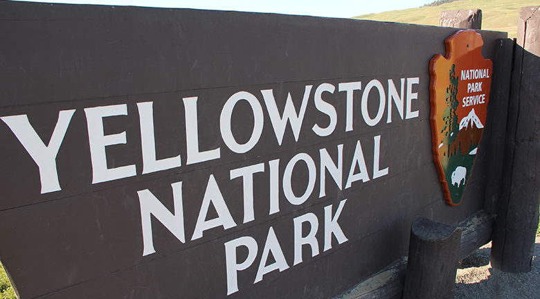 Esta imagem é uma fotografia de uma placa para o Parque Nacional de Yellowstone.