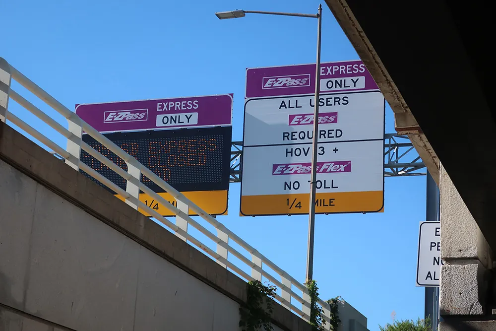 Several large E Z Pass road signs in a cluster. They indicate that the lane is E Z Pass Express Only. One says &ldquo;All Users E Z Pass Required,&rdquo; while another indicates that H O V lane requires no toll.