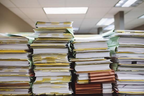 Case files stacked high on top of a desk
