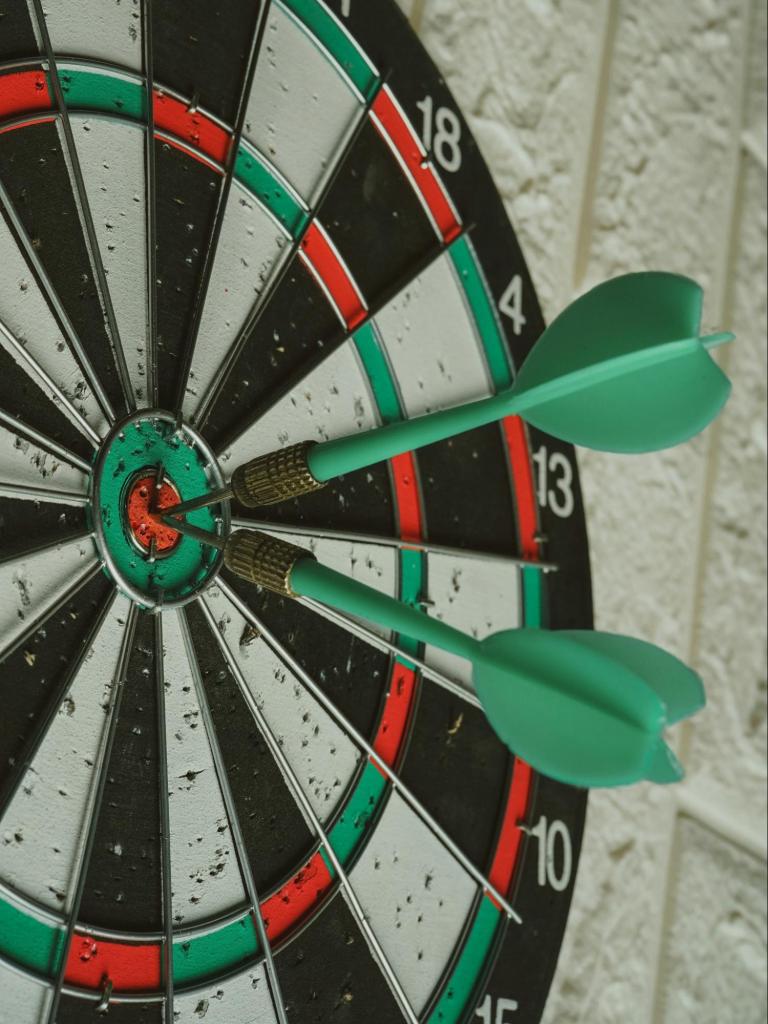 darts in the bullseye of a dartboard.