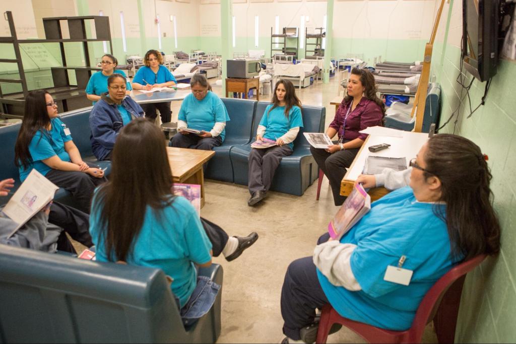 programming at a women&rsquo;s correctional facility: multiple women sit in a circle having a discussion.