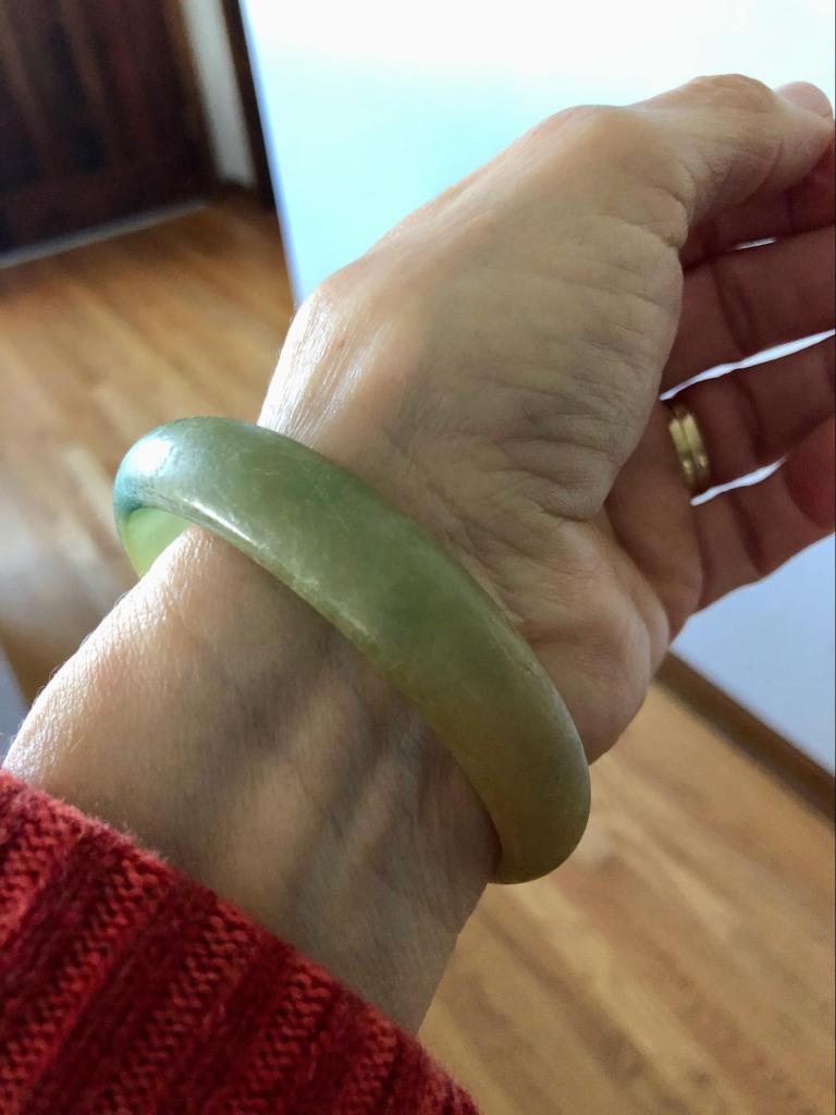 A jade bracelet on a person&rsquo;s wrist.