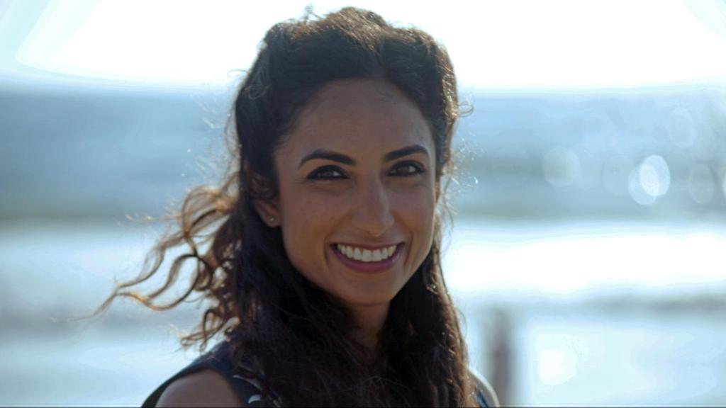 A picture of woman with long dark hair smiling warmly.