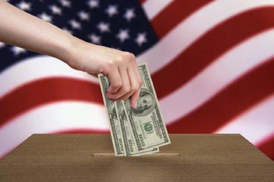 An image of someone putting money in a ballot box with a US flag in the background.