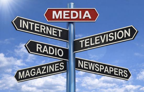 A signpost points in multiple directions&mdash;Internet, Television, Radio, Magazines, and Newspapers&mdash;illustrating the diverse and evolving channels through which Americans receive news and political information in the modern media landscape.