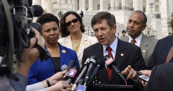 Members of Congress speak with reporters outside the U.S. Capitol during a press conference.