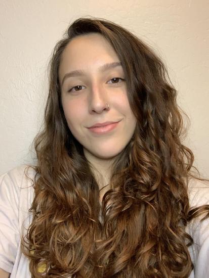 Nicole with long brown hair smiling at the camera.