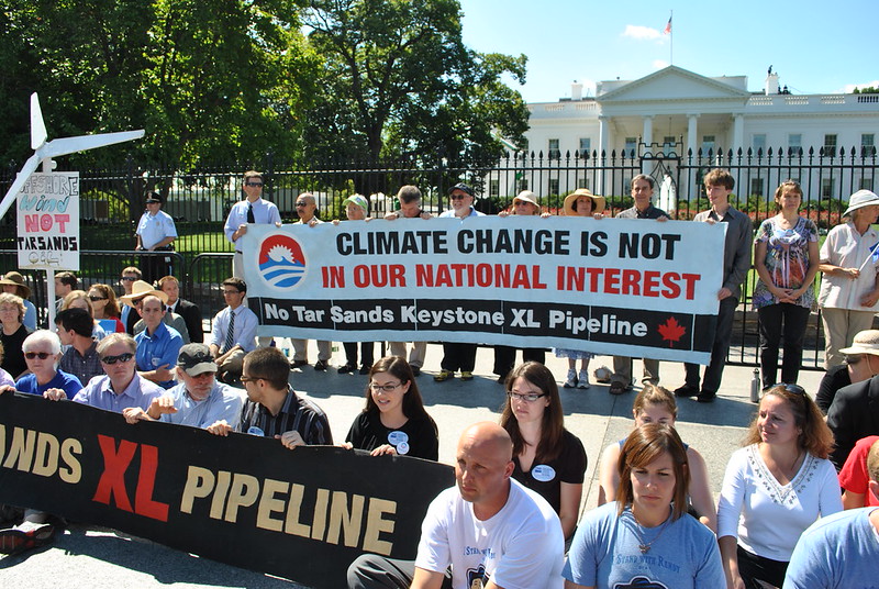 Protesters in front of White House with banners reading: "Climate change is not in our national interest" and "No Tar Sands XL Keystone Pipeline."