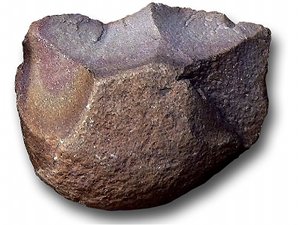 Picadora de piedra de tradición Oldowan que aparece como una piedra redondeada con un lado roto para producir borde afilado.