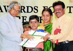 a boy receiving an academic award from an adult while his parents look on