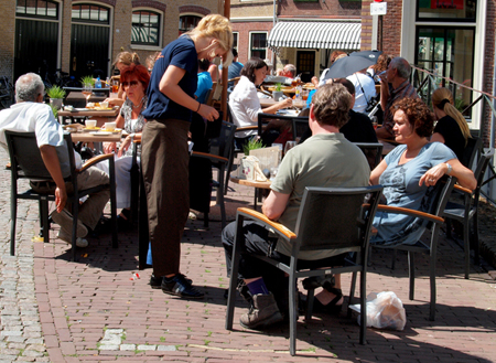 La serveuse sert les clients dans un café en plein air.