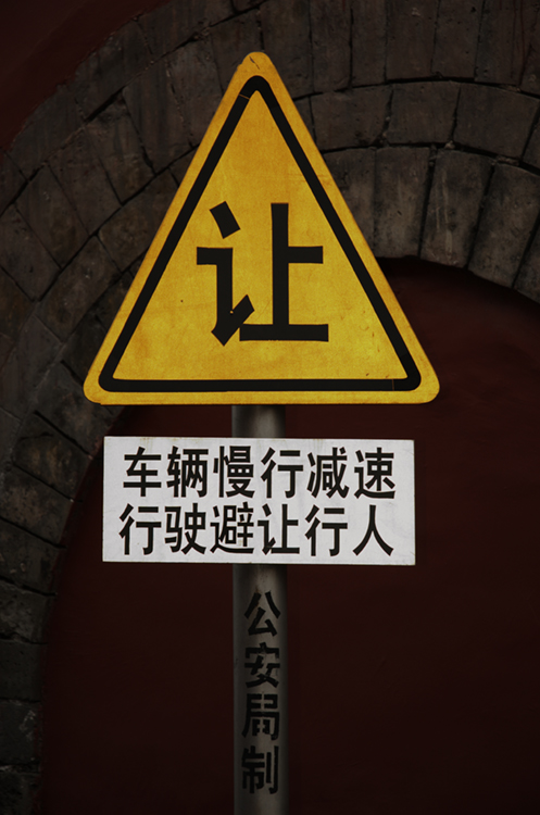 تظهر الصورة (ب) علامة مكتوبة باللغة الصينية.