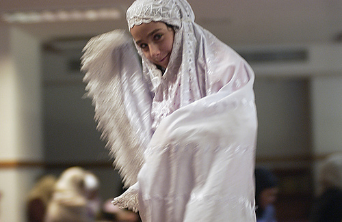 Un enfant vêtu d'un costume culturel tout blanc est représenté.