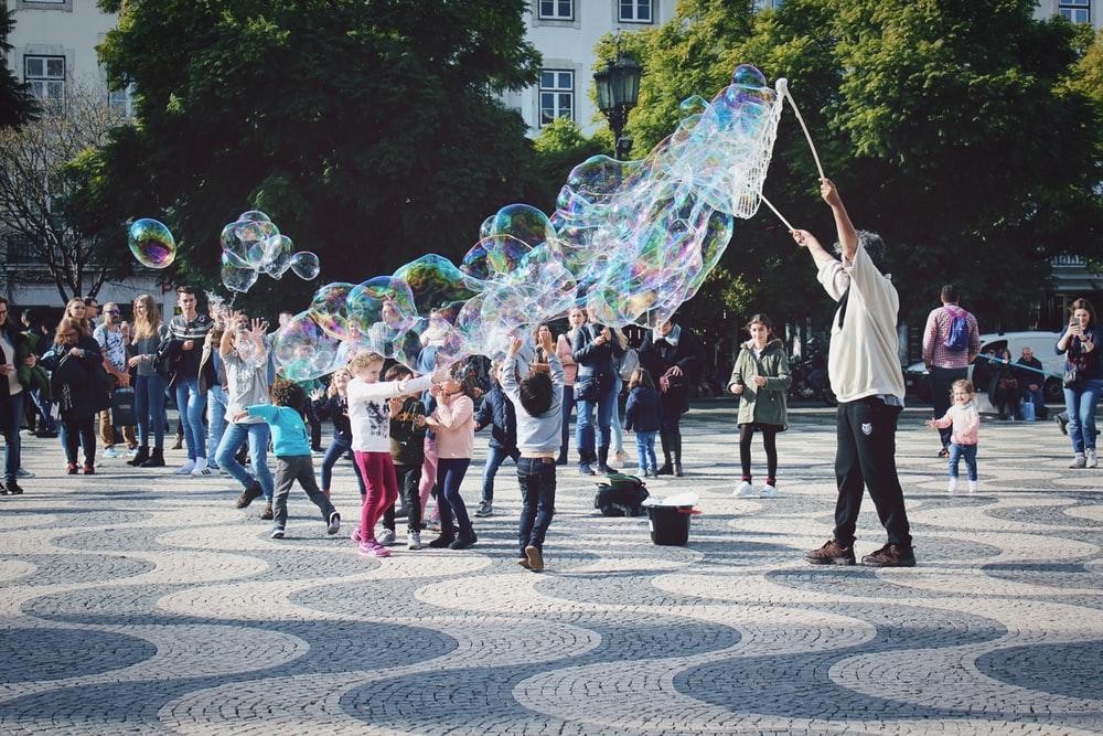 grupo de niños jugando burbuja en el parque
