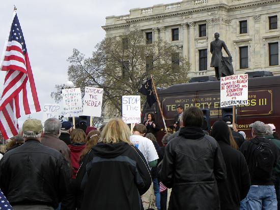 A photo of a crowd of people standing in front of the Tea Party Express Bus outside of the state capitol building for a rally 
