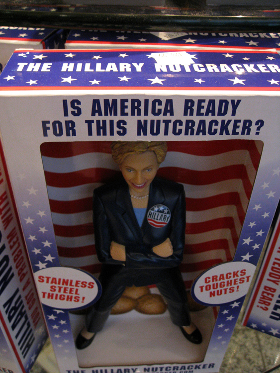 تظهر شخصية لعبة هيلاري كلينتون في صندوق تغليف مكتوب عليه «هل أمريكا جاهزة لكسارة البندق هذه؟»