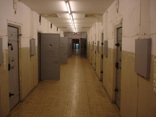 Figure b shows the hallway of a correctional facility.