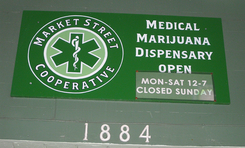 Foto de uma placa de um dispensário de maconha medicinal mostrando que o negócio está aberto