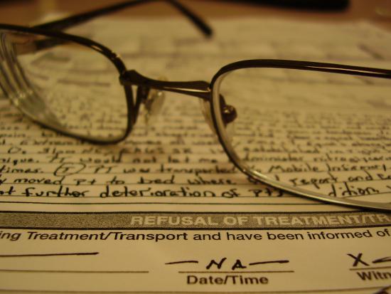 Refusal of treatment form with a pair of glasses on top