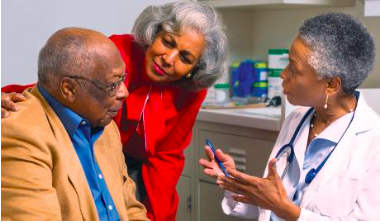 Medical doctor talking to an elderly patient and his caregiver