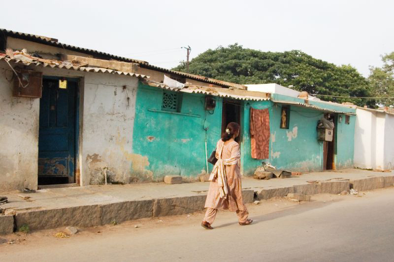 Uma mulher na Índia é mostrada por trás andando pela rua.
