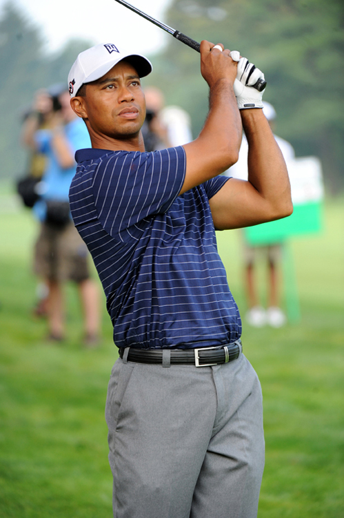 Une photo du golfeur Tiger Woods tenant son club de golf en l'air sur le terrain de golf après avoir frappé une balle de golf