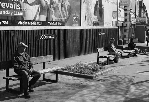 A person sitting on a bench far away from others.