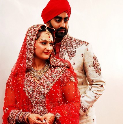 A young couple posing for wedding photos in traditional Indian attire.