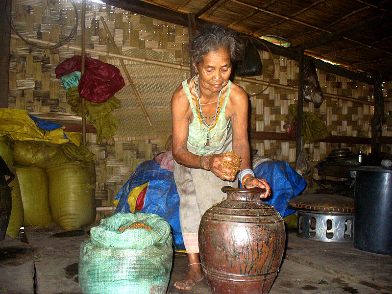 Brao woman making rice wine in a jar