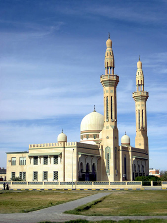 É mostrada uma mesquita, um grande edifício com uma grande cúpula e duas cúpulas menores e duas torres, chamadas minaretes.